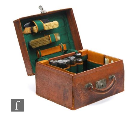 An Edwardian lady's dressing case fitted with four silver topped bottles, three brushes and other tools, width 33cm. 