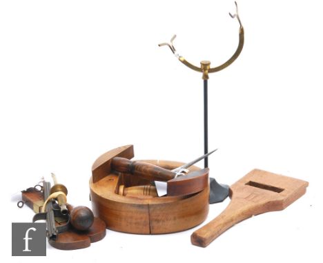 An early 20th Century circular beech wood hat stretcher, a portable hat stretcher, an upholstery webbing stretcher, a milline