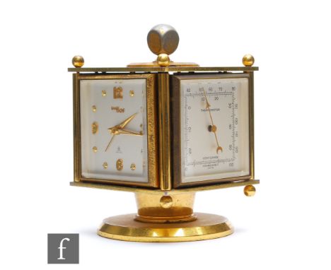 A 1960s Imhof combination desk clock, each revolving face including a hygrometer, a barometer and a thermometer, on brass ped