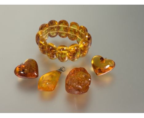 A collection of dark and light amber jewellery to include: a secrional bracelet D x6 cm&nbsp; two heart shaped pendants L x 3