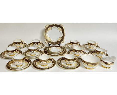 A Tuscan China gilt decorated pat tea service comprising eleven cups, twelve saucers, twelve tea plates (for trios), two serv