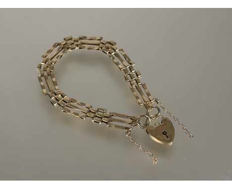 A 9ct gold gate link bracelet with heart shaped padlock and safety chain D x 8cm 10.39g