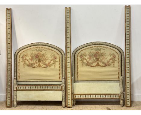 A pair of Belle Epoque French single beds, with arched carved giltwood frames, with woven tapestry headboards, reeded giltwoo