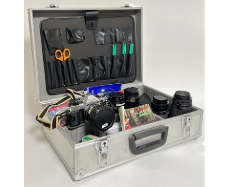 A Canon AE-1 Program camera and manual together with a hard carry case containing various lenses and accessories