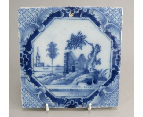 An eighteenth century tin-glazed earthenware blue and white hand-painted tile, c. 1770. It is decorated with a landscape scen