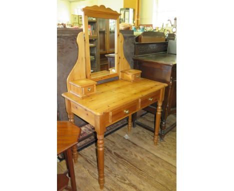 A pine dressing table, with swivel mirror and trinket drawers over two frieze drawers on turned tapering legs, 91cm wide