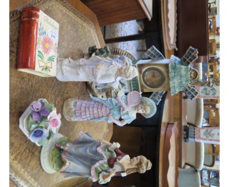 A continental ceramic table clock in the form of a windmill, with a figure and mule below, 35cm high, three other continental
