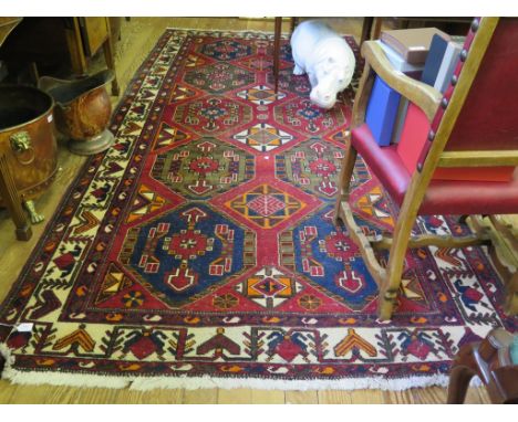 A Mehran carpet with two rows of five medallions on a red field and ivory border, 326cm x 166cm