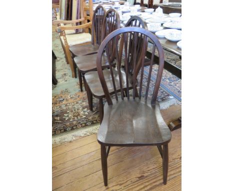An Ercol dining table, the moulded rectangular top on a shaped trestle base, 183cm long, and a set of four Windsor type chair