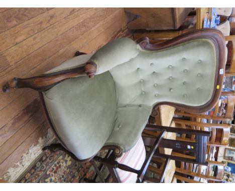 A Victorian mahogany spoonback armchair, the button upholstered back over moulded scroll arms and legs, on castors