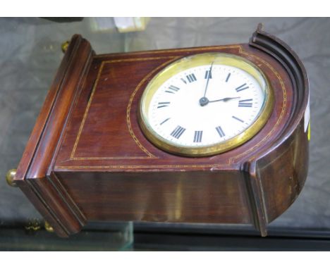 An Edwardian mahogany timepiece with chequer stringing, the arched case enclosing an enamel dial on brass ball feet