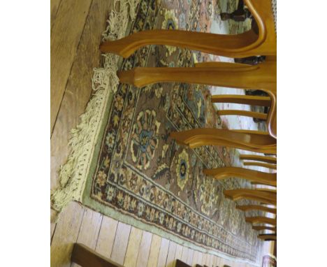 A Persian style carpet, the green field with blue and faun medallion and spandrels filled with floral sprays within a multipl