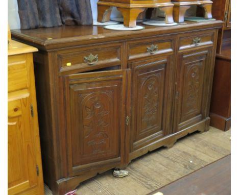 An Edwardian walnut sideboard, with three frieze drawers above three floral carved panel doors on bracket feet, 250cm wide