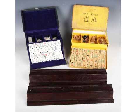 A 20th century bone and bamboo Mah-jong set, within a leather case, together with another Mah-jong set and two wooden tile st