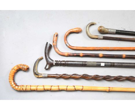 A late 19th century ebony walking cane with a rhino horn handle and silver collar, length 89cm, two other horn handled walkin