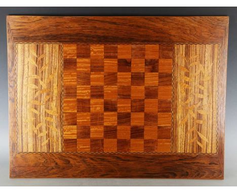 A 20th century Arts and Crafts style marquetry inlaid reversible chess and backgammon board, inlaid with stylized plants and 