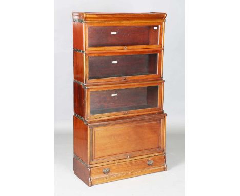 An early 20th century mahogany Globe Wernicke four-section library bookcase, fitted with three glazed doors and a panelled do