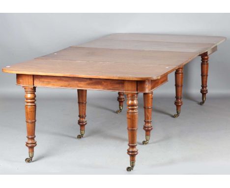 A late Regency mahogany extending dining table, on ring turned tapering legs and brass castors, the top with two extra leaves