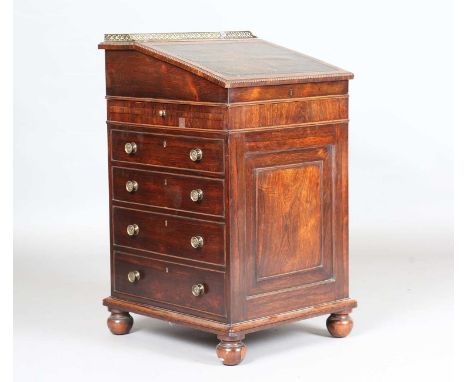 A Regency rosewood Davenport desk, in the manner of Gillows of Lancaster, the sliding top with pierced gilt metal three-quart