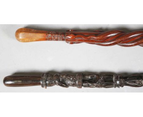 A late 19th/early 20th century ethnic carved walking stick, the shaft modelled with three spiralling serpents, length 86cm, t