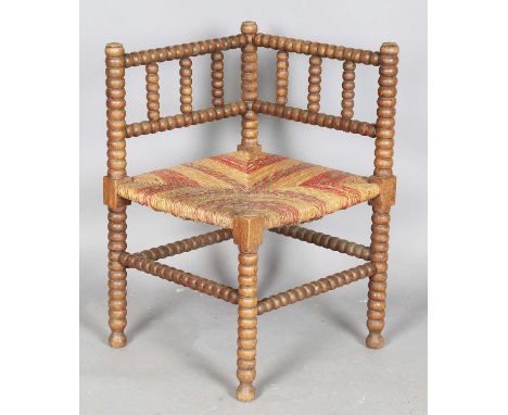 An early 20th century French bobbin turned beech corner chair, height 66cm, width 44cm.