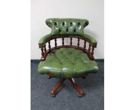 A green button leather swivel captain's armchair 