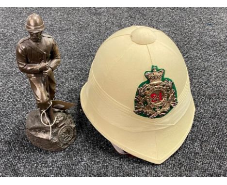 A resin figure of a Zulu War soldier and replica helmet 