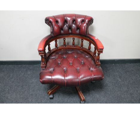 A red button leather swivel captain's armchair 