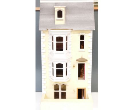 A three storey dolls house with attic with hinged door and lift up roof, wired for battery powered lighting, H106 x W47 x D50