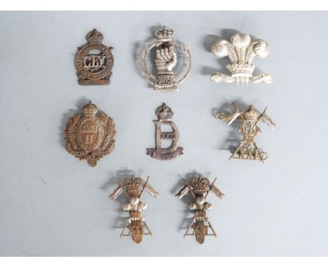 A small collection of British Army cap badges including 18th Hussars, 22nd Dragoons and 21st Lancers