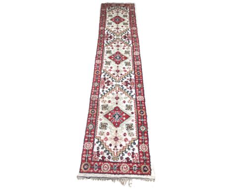 A North West Persian style hall runner with three medallions on cream field, 325 x 72 cm.&nbsp;