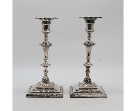 A pair of Mappin &amp; Webb silver plated table candlesticks in the 18th century style, each having a gadrooned sconce of kno