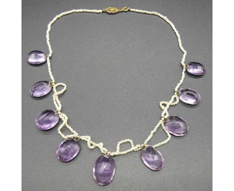 An early 20th century amethyst and seed pearl necklace by Liberty &amp; Co, the nine oval cut graduated amethyst stones house