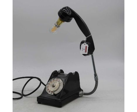 A black bakelite cased rotary dial telephone, converted into a desk lamp, height 40cm