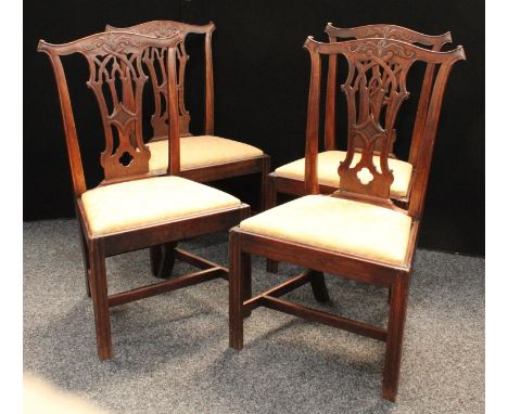 A set of four George III mahogany Chippendale design dining chairs, Cupid's bow cresting rails carved with scrolling acanthus