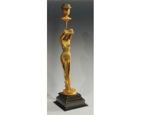 An Art Deco inspired 'gilt' metal figural table lamp, as a nude female, stepped square base, 57.5cm high over fitting