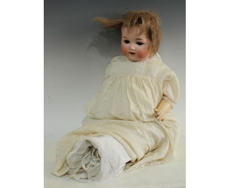 An Armand Marseille 990 socket head doll, sleeping brown eyes, open mouth with two teeth, short light brown wig, impressed Ar
