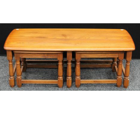 An Ercol elm nested coffee table, the largest 115cm wide