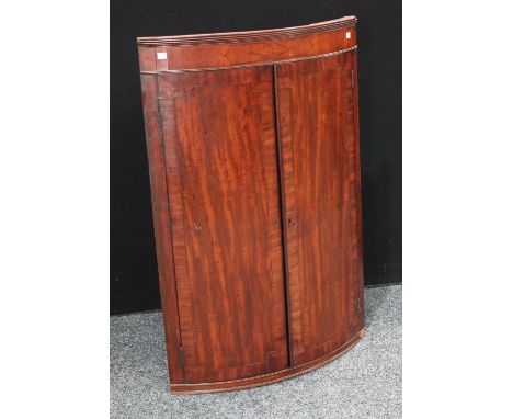 A George III mahogany bow-front corner cupboard, 104cm high