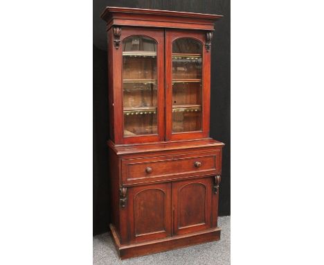 A Victorian mahogany secretaire library bookcase, outswept cornice above a pair of glazed doors enclosing three adjustable sh