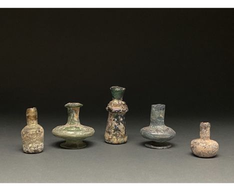 1-400 AD. Roman and Late Roman. A lot of five blown glass vessels, comprising (L-R): a cylindrical bottle with a sloping shou