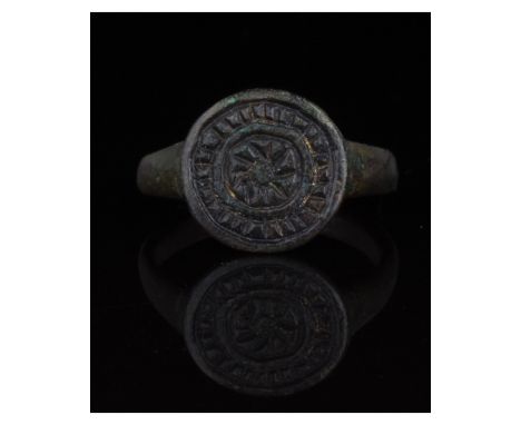 1-300 AD, Roman. Ring with circular loop, and raised round bezel bearing an incised decoration comprising a sun motif surroun