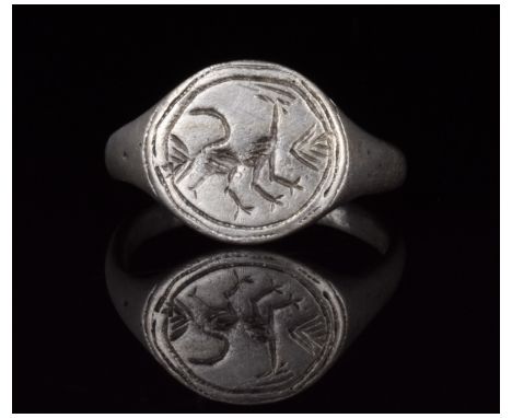 700-1100 AD, Viking Age. A silver ring with D-shaped hoop and flattened, circular bezel bearing an incised depiction of a sty