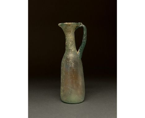 c. 400. Late Roman. A beautiful light blue jug comprising a slightly tapering body, a long straight neck, a wide flaring, out