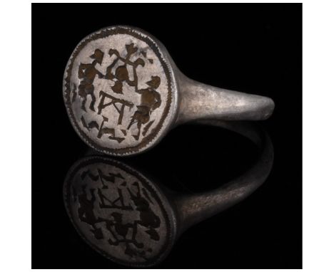 c. 1200-1600 AD. Medieval. Silver ring with circular hoop and a round bezel. The bezel bears incised decoration in the form o