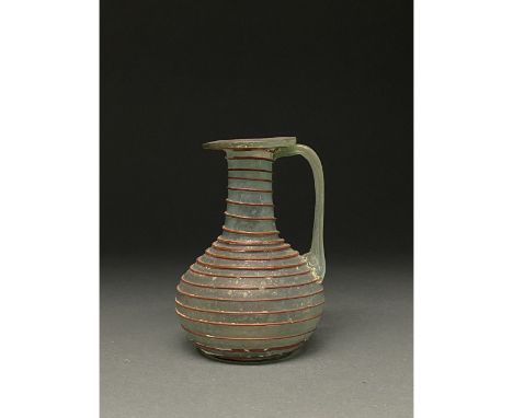 Ca. 1-300 AD Roman. A beautiful light green jug with a long straight neck, flat, discoid outward flexed rim, a flaring globul
