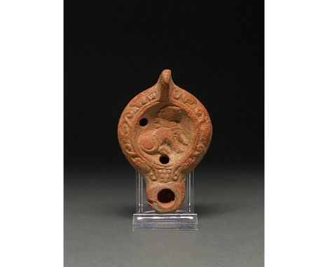 1-300 AD. Roman. A beautiful ceramic  lamp depicting a lion leaning back on its haunches wreathed by grape vines. The oldest 