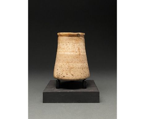 CA. 2000 BC; Egyptian. A crème coloured steatite jar comprising a gently flaring body, a flat base and a thick slightly out-t