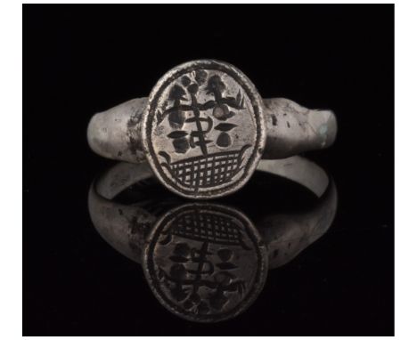 c. 1000-1500 AD. Medieval Crusader period. A silver ring with a round hoop and a circular bezel bearing incised decoration in