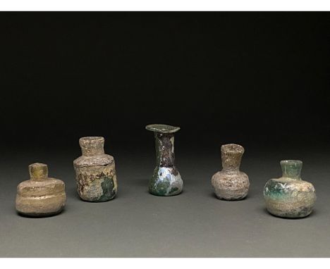 1-400 AD. Roman and Late Roman. A lot of five blown glass vessels, comprising (L-R): A squat cylindrical bottle with a cylind